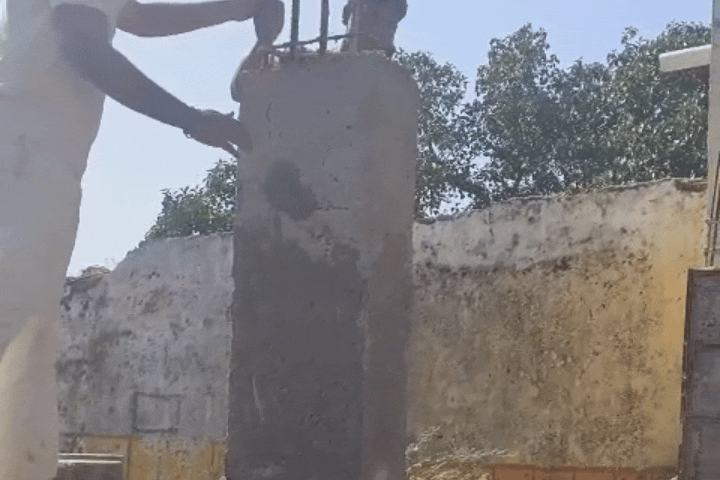 निर्माणाधीन आरसीसी पिल्लर पर दरारें दिखाते हुए ग्रामीण
